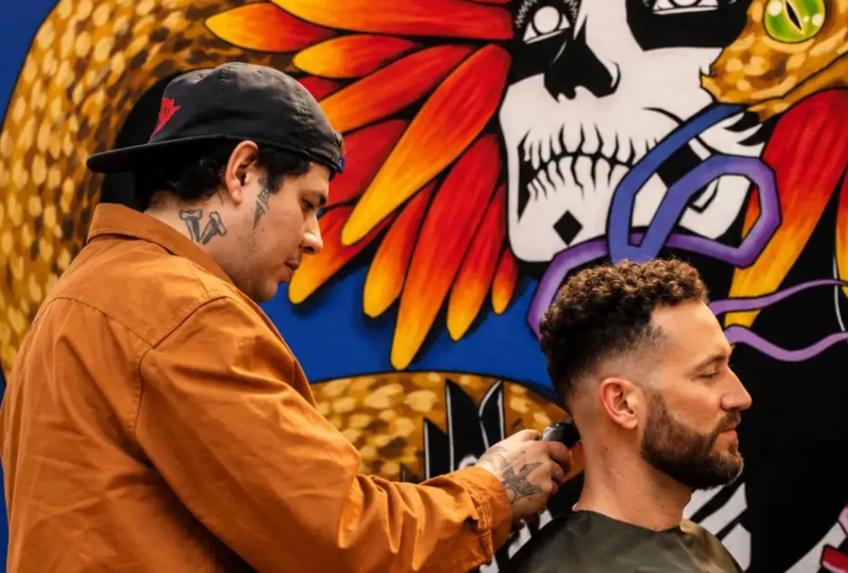 Barbero de Bacaanda haciendo un fade frente al mural del estudio
